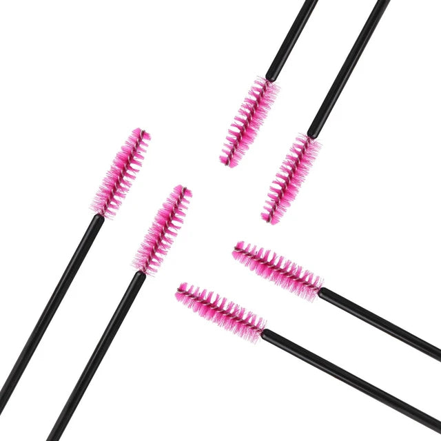 a group of four mascara brushes sitting next to each other