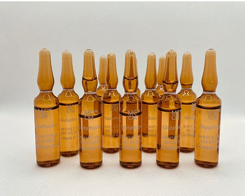 A collection of MCCM glutathione ampoules in amber glass, showcasing 10 vials labeled with dosage details and branding.