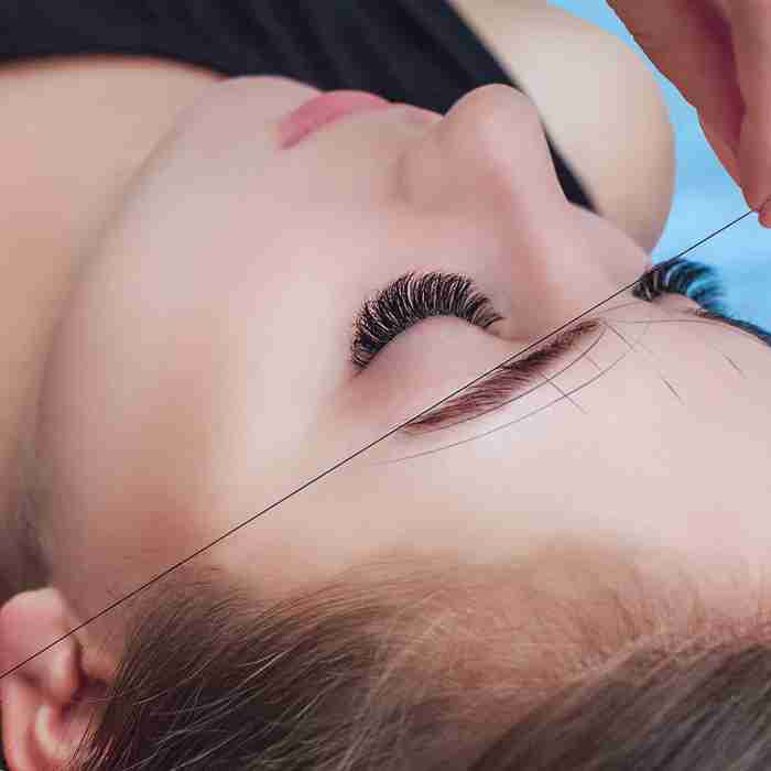 a woman getting her eyelashes brushed by a hair stylist