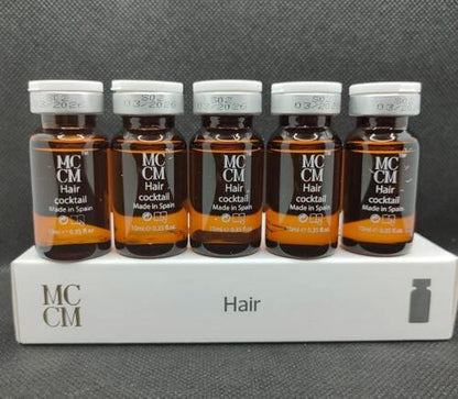 six bottles of hair oil sitting on top of a white box